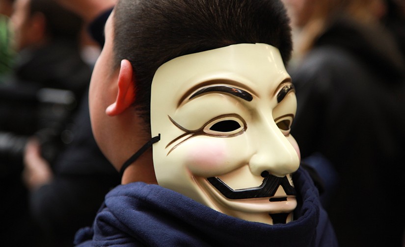 Photo of a man with a mask turned backwards around his head.