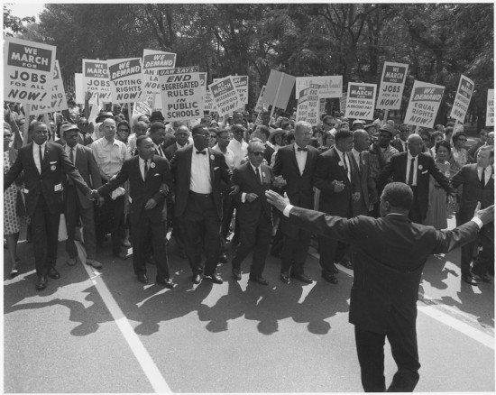 Figure (b) shows a large group of marchers for civil rights.