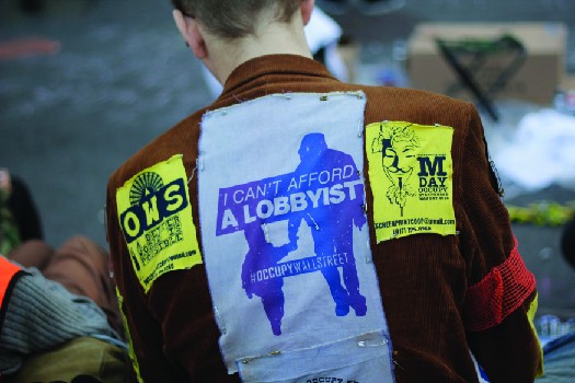 An image of the back a person wearing a jacket. A patch on the jacket reads 