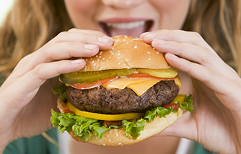 Photo of girl eating a hamburger.