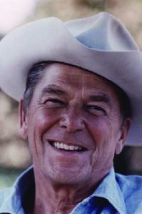 A photo of Ronald Reagan wearing a cowboy hat and denim shirt.