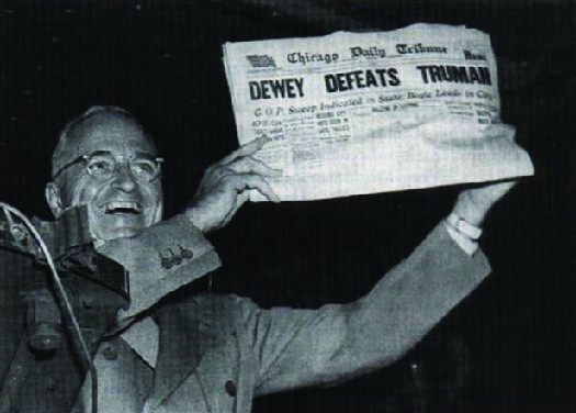 Photo shows Harry S. Truman displaying a newspaper whose headline states 