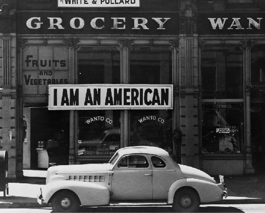 A photo of sign in a store front that says I Am An American