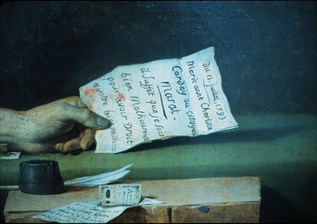 Marat’s hand holding the letter. There is blood on the letter, which can clearly be read. 