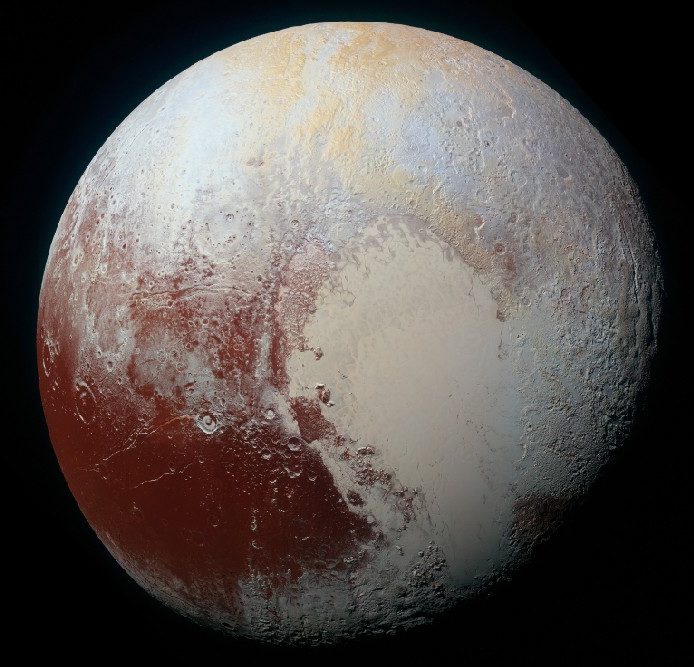 A global color image of Pluto, showing a dark area in the lower left covered with impact craters, and a larger light area in the center and lower right that is flat.