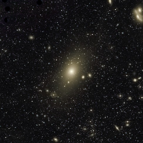 Central Region of the Virgo Cluster. This image is dominated by the giant elliptical galaxy M87 at center. Hundreds of smaller, fainter galaxies seem to swarm around M87.