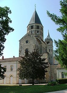 The remains of the Abbey of Cluny, a benedictine monastery. It is made of gray stone with several spires. 