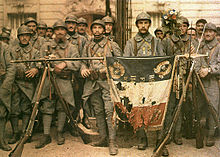 Men from the 114th infantry holding a tattered French flag.