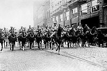 French cavalry marching down a street in formation. 