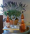 Image of wine bottles on a table with a plant in the background.