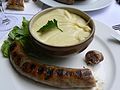 A sausage and cheese sauce on a plate. 