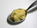 A dollop of dijon mustard on a silver spoon.