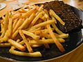 Steak and fries on a dish. 