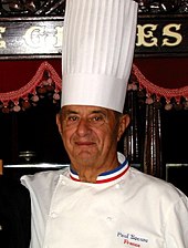 Image of Paul Bocuse with a chef's hat on.