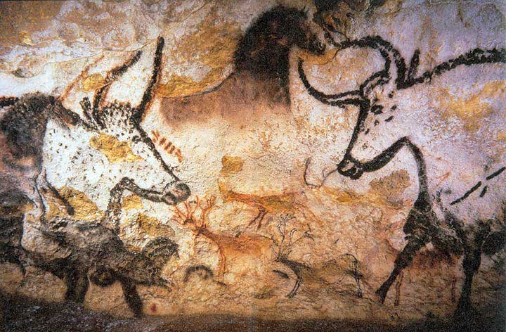 Image from the cave at Lascaux of wild animals. Among the most prominent in image are two bulls outlined in black facing one another. In the middle, there is a chalked entirely in black.