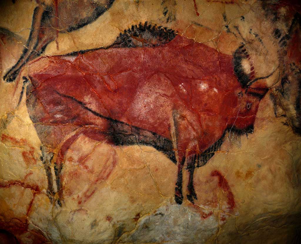 An image of a large red bison facing right, drawn on the light tan color rock wall