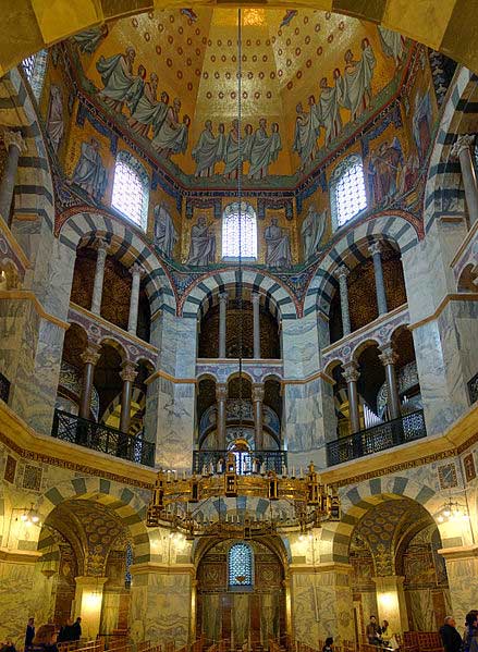Interior picture of the Palatine Chapel at Aachen The surviving mosaics begin above eye level at the piers or arches and span upward into the dome.