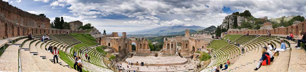 A contemporary photograph of a panoramic view of the ancient Greek theatre in Taormina, Sicily, Italy.