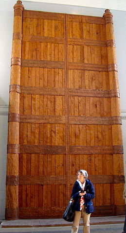 Photo depicting the scale of the gate. A woman stands in the center and is approximately 1/8th the height and width of gate.