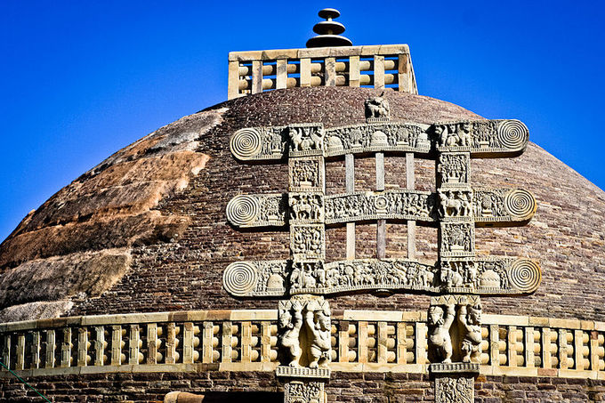 This is a current-day photo of the Stupa at Sanchi, India, illustrating the mound-like or hemispherical structure of stupas. It is decorated with ornated gold metalwork.