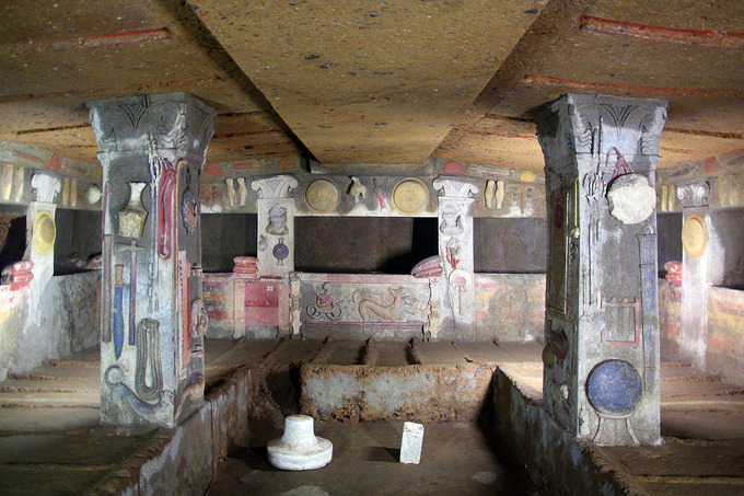 This is a photo of the interior of the Tomb of the Reliefs. The walls and the two freestanding pilasters are decorated with stucco reliefs of objects from daily life. These include household items, pets and other animals.