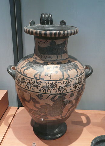 This is a photo of a water carrying vessel with three handles. It is decorated with a with black-figure paintings of mythological creatures.