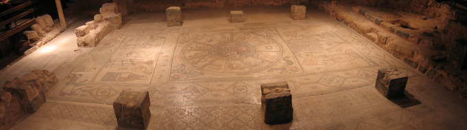 This is a panoramic photo of the nave mosaics in Beth Alva. It shows three panels. The left panel depicts the binding of Isaac. The center panel depicts a zodiak circle. The right panel depicts a synagogue scene.