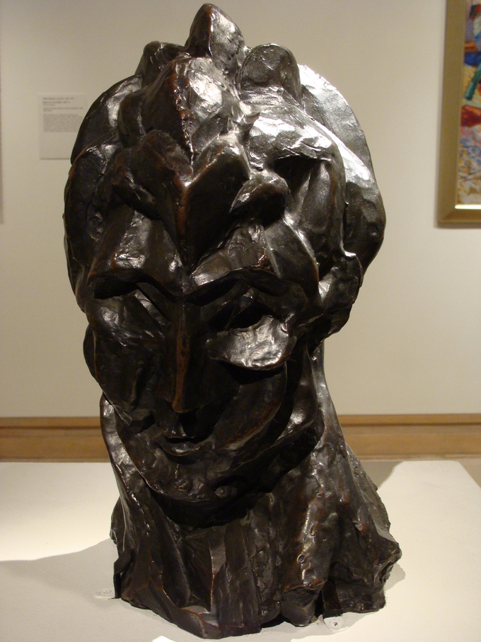 The surface and structure of this sculpture of a woman's head are broken up into fragmented forms.