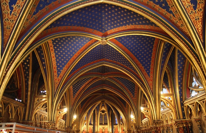 The ceiling is richly colored and decorated. The prominent design is gold fleur de lys on a blue background.