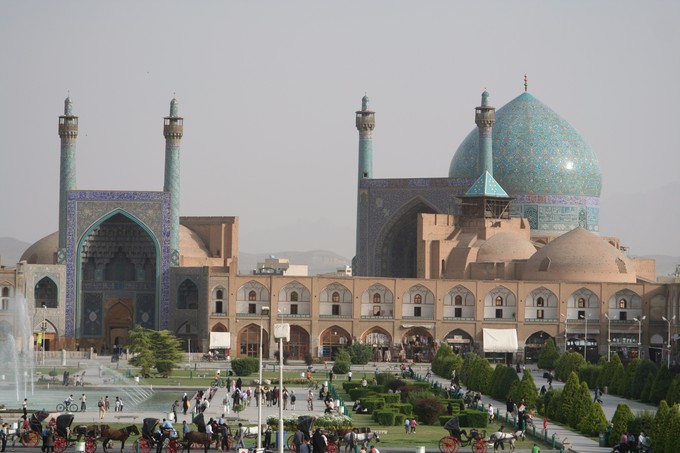 This photo shows the Imperial Mosque, Isfahan, Iran. It is panorama that displays the architecture, including a large blue-domed mosque.