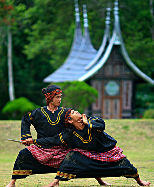 This is a current-day photo of two men practicing Silat Minangkabaut, a particular form of silat, outdoors.