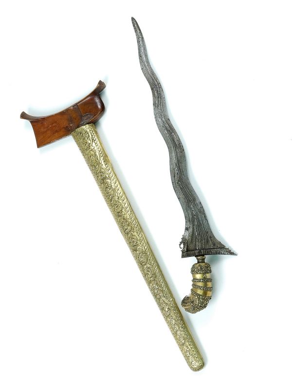This photo shows a kris and an axe. The kris is an asymmetrical dagger noted for its distinctive wavy blade patterning.