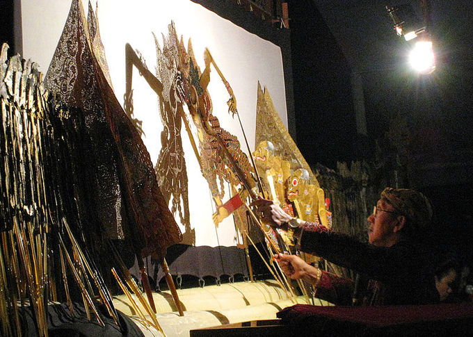 This current-day photo shows a backstage view of a wayang performance. The wayang kulit performance by the famous Indonesian dalang (puppet master) Ki Manteb Sudharsono, with the story Gathutkaca Winisuda.