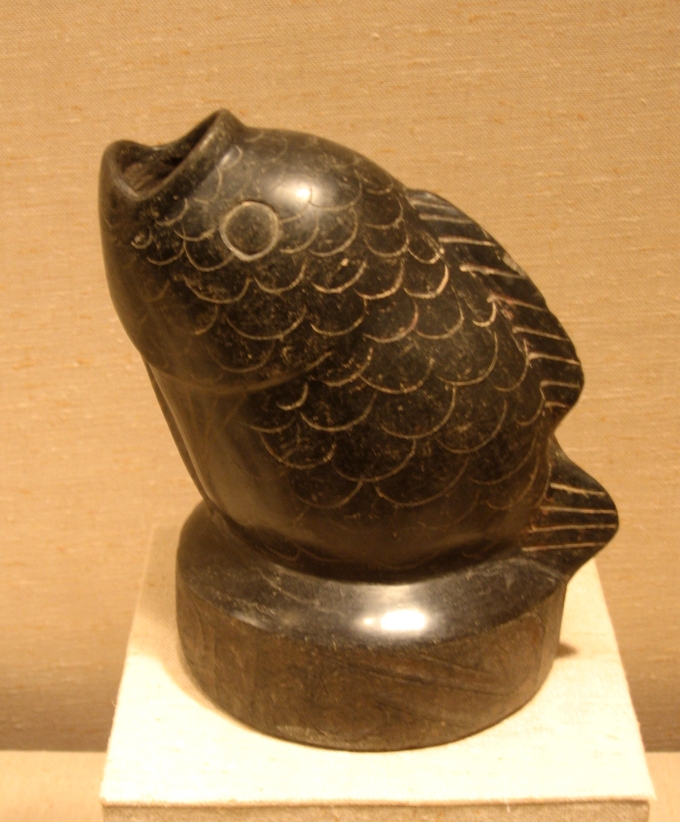 A vessel in the shape of a fish with the mouth as the spout.