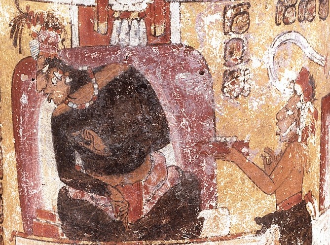 The Maya lord is depicted sitting, looking down and to the side. On the right, a courtier approaches him with offerings.