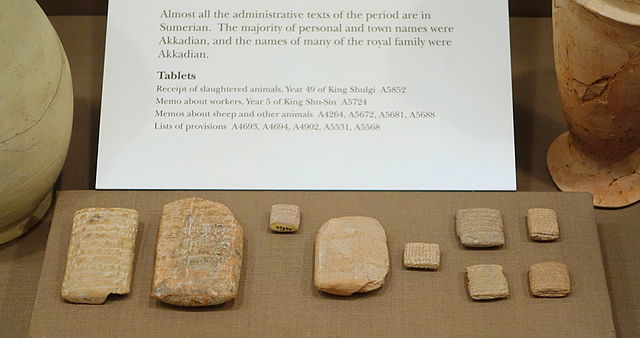 Several small stone tablets and tiles covered with cuneform writing.
