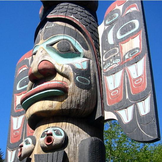 This totem pole depicts a giant head painted in various colors.