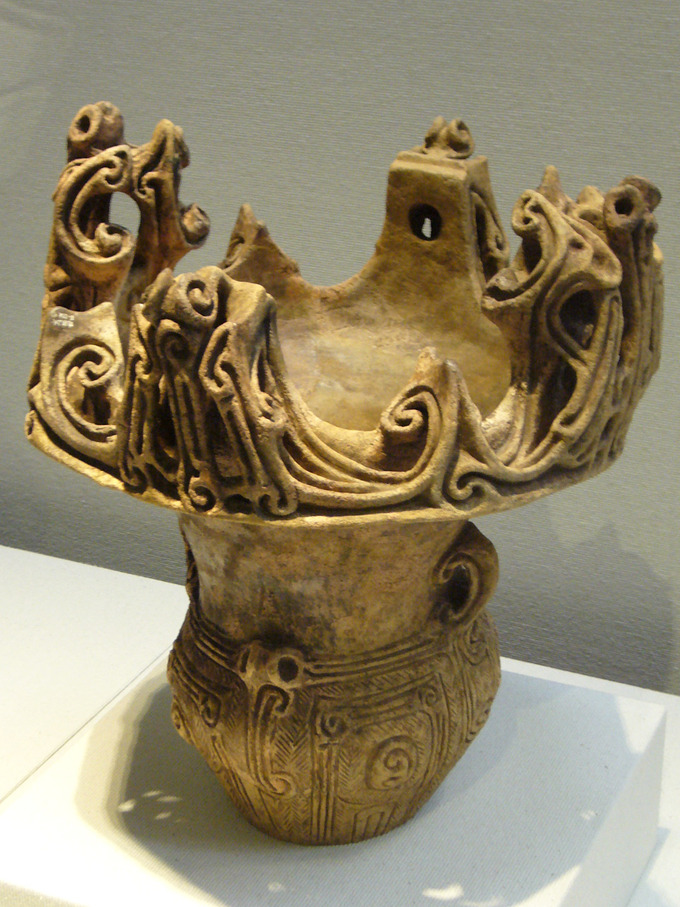 A vessel with an elaborately decorated base and an “open,” crown-like top that is also elaborately decorated.