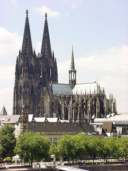 External image of the cathedral. The building is dominated by its huge spires. Externally the outward thrust of the vault is taken up by flying buttresses in the French manner.