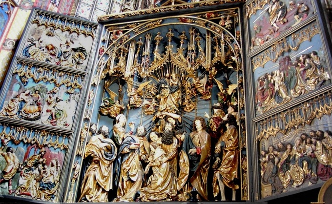 The center of the altar shows the death of Jesus' mother, Mary, in the presence of the Twelve Apostles. The side panels show the six scenes of the Joys of Mary.