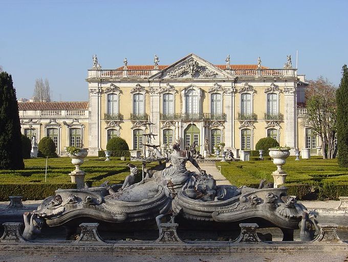Palace is pictured with an elaborate fountain in the foreground.
