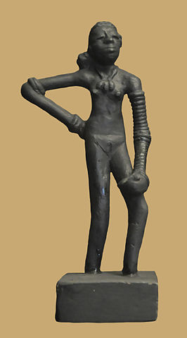 Photo depicts a bronze statuette of a nude woman standing with her hand on her hip.