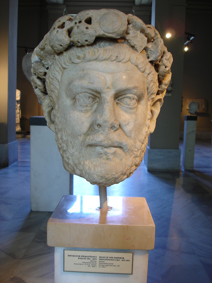 This is a photo shows a Portrait of Diocletian in a museum case. Diocletian achieved stability by establishing the Tetrarchy, Greek for rule by four.