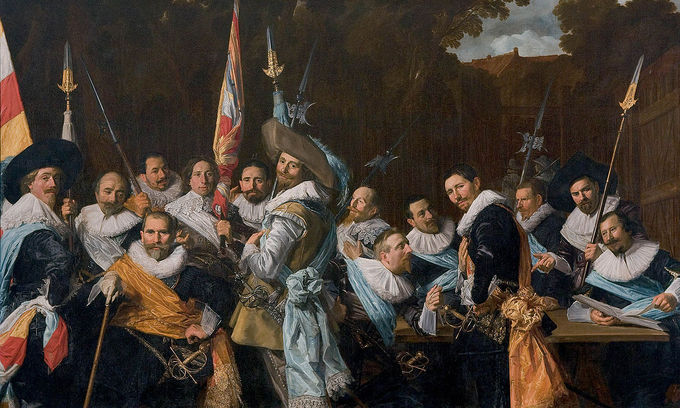 In this group portrait, the men are seated outside in the courtyard wearing sashes.