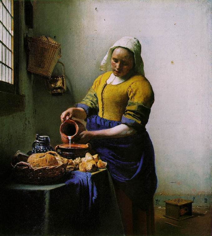 A maid or servant is seen in a plain room carefully pouring milk into a squat earthenware container on a table. Also on the table are various types of bread. She is a young, sturdily built woman wearing a crisp linen cap, a blue apron and work sleeves pushed up from thick forearms. A foot warmer is on the floor behind her. Intense light streams from the window on the left side of the canvas.