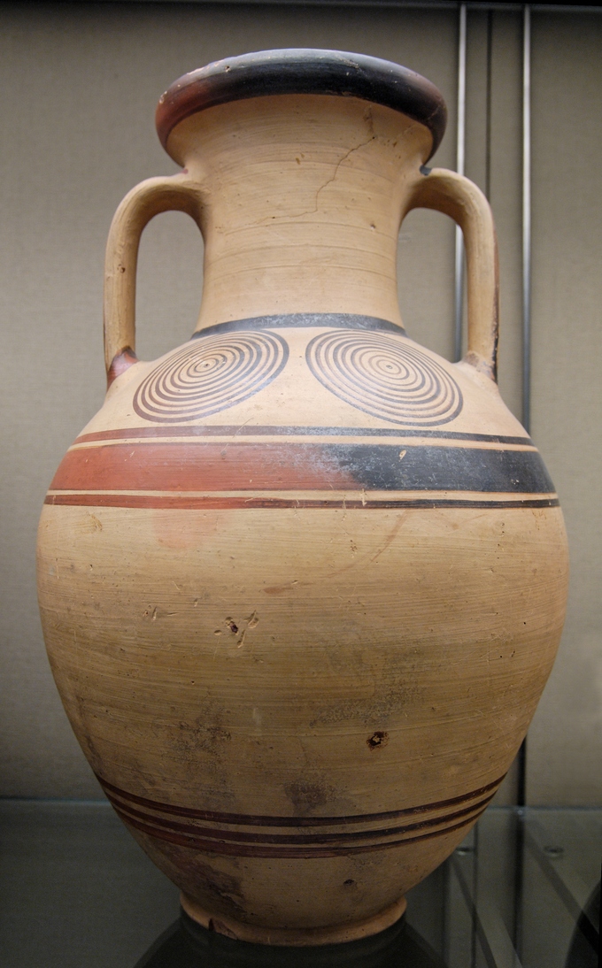 Photo of a tall jar with two handles and a narrow neck. It is decorated with two geometric circles.