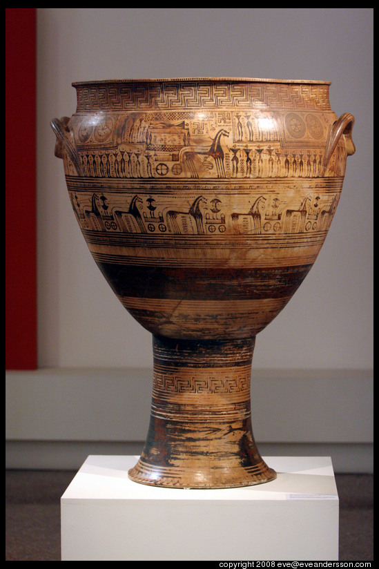 Color photo shows a Greek krater (large vase used for mixing wine). It is decorated with a variety of geometric patterns.