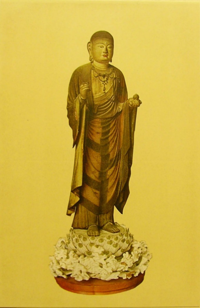 The buddha is depicted in a golden color, standing on an elaborately decorated base.
