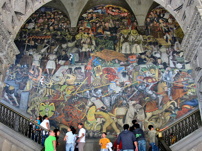 This current-day photo shows a mural in the main stairwell of the National Palace by Diego Rivera. The mural is a huge, colorful collection of indigenous images.