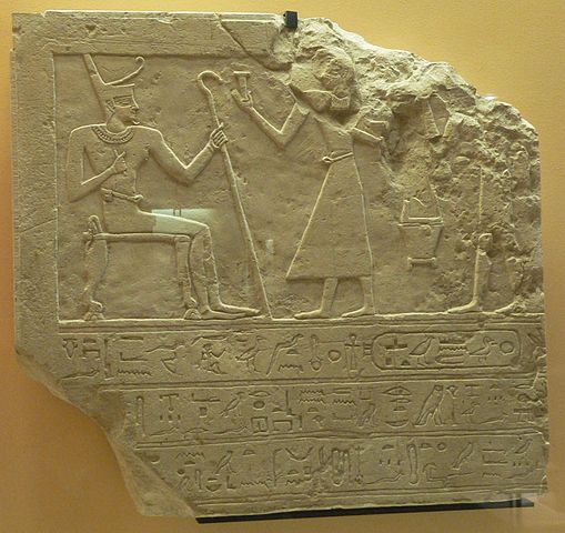 Mentuhotep II receiving offerings as he is seated, holding what looks like a cane.